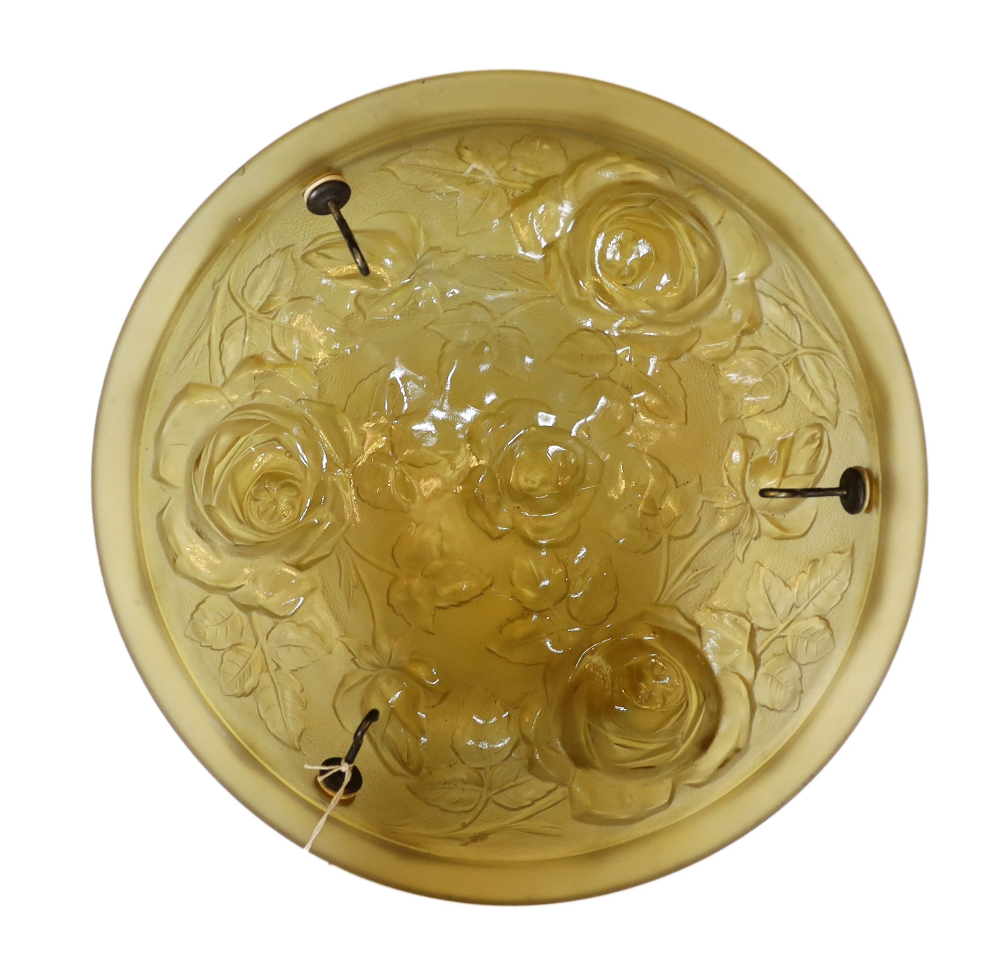 A 1920s French moulded amber glass light bowl, decorated with roses, with chain set and ceiling rose, diameter 35cm